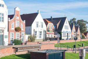 una fila de casas en un pueblo con un cubo de basura en GREATsiel - die großartige Ferienwohnung in Greetsiel, en Greetsiel