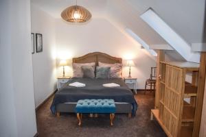 a bedroom with a bed with a blue bench in it at Őri Art Inn in Őriszentpéter