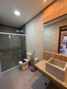a bathroom with a shower and a toilet and a sink at Naim Milagres in São Miguel dos Milagres