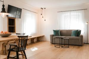 a living room with a couch and a table at St. Vigilius modern historic apartments in Nalles