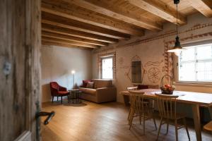 eine Küche und ein Wohnzimmer mit einem Tisch und Stühlen in der Unterkunft St. Vigilius modern historic apartments in Nals