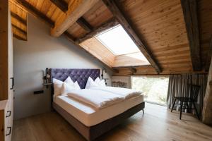Schlafzimmer mit einem großen Bett mit einem lila Kopfteil in der Unterkunft St. Vigilius modern historic apartments in Nals