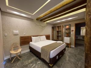 a bedroom with a large bed and a chair at Naim Milagres in São Miguel dos Milagres +49 photos