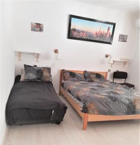 um quarto com duas camas e uma televisão na parede em Zimmer Arad Dead Sea, Big and Confortabוl Apartment, logic cost - במחיר שפוי em Arad