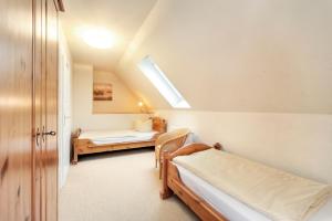 a attic bedroom with two beds and a window at Kirr in Zingst