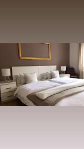 ein Schlafzimmer mit einem großen weißen Bett mit zwei Lampen in der Unterkunft Ela Apartments Berlin in Berlin