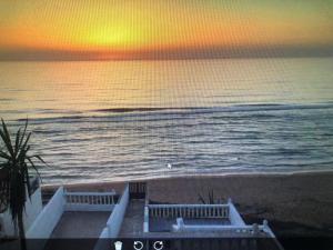 a view of the ocean at sunset from a beach at Villa Keltoum in Moulay Bousselham