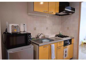 a small kitchen with a sink and a microwave at Marvelous Kokubunji - Vacation STAY 29877v in Kokubunji