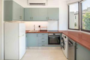 a kitchen with blue cabinets and a white refrigerator at Urban View Studio in Heraklio