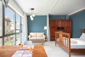 a bedroom with blue walls and a bed and a couch at Urban View Studio in Heraklio