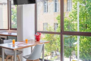 kuchnia ze stołem i krzesłami oraz duże okno w obiekcie Urban View Studio w Heraklionie