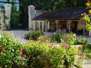 a garden with flowers in front of a building at Ferme du bois de Veude in Anché