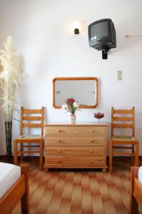 PosidhoníaにあるKrinakiaのベッドルーム(ドレッサー、テレビ、椅子2脚付)