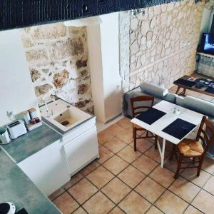 a kitchen with a table and a counter top at Maison avec jacuzzi in Saint-Mitre-les-Remparts