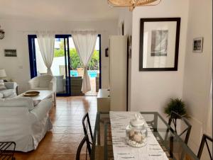 een woonkamer met een glazen tafel en een bank bij VILLA DUNIA by Villitas in Playa Blanca