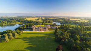 una vista aerea di una grande casa su un rigoglioso campo verde di The Old Doctors Retreat- Near Soho Farmhouse a Sandford Saint Martin