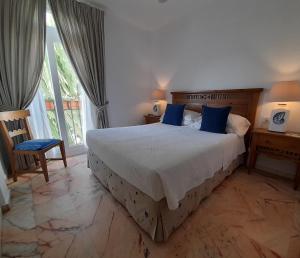 a bedroom with a large bed with blue pillows at miKasa Agua Amarga & SPA in Agua Amarga