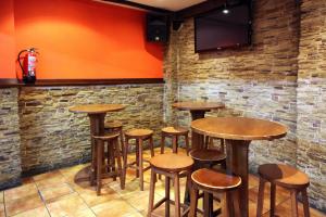 a row of wooden tables and stools in a bar at Hostal Antxitonea in Elizondo