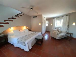 a bedroom with a large bed and a staircase at miKasa Agua Amarga & SPA in Agua Amarga