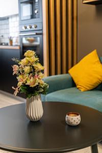 un vase de fleurs sur une table dans le salon dans l'établissement Apartament Delux, à Bacău