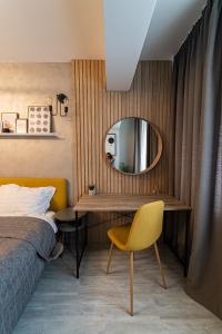 - une chambre avec un lit et un miroir dans l'établissement Apartament Delux, à Bacău