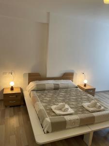 a bedroom with a large bed with two towels on it at Holiday Apartment in Vlore in Vlorë