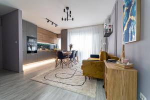 a living room with a yellow couch and a kitchen at Delux Suite - Apartament 100 de m2 cu 3 camere și parcare gratuită, lângă Arena Mall in Centrul Bacău in Bacău
