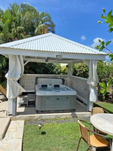 a gazebo with a hot tub in a yard at Beau Bungalow a Port-Louis in Port-Louis