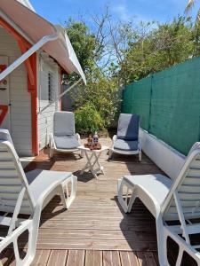路易港的住宿－Beau Bungalow a Port-Louis，木甲板上配有两把椅子和一张桌子