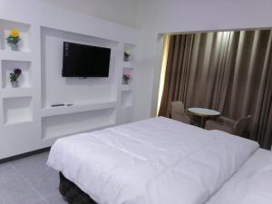Ţarīfにあるفندق زيلامسيのベッド1台、薄型テレビが備わるホテルルームです。