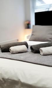 uma fila de três camas com toalhas em Superb 2 beds 2 baths New Apartment w/ Garden+Patio em Bournemouth