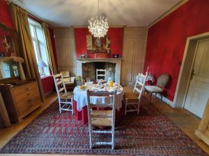 a dining room with a table and a fireplace at Les Jardins in Hoymille