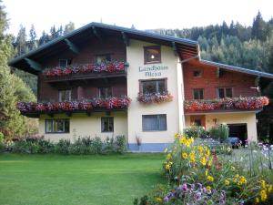 Un bâtiment avec des fleurs devant lui dans l'établissement Landhaus Alexa, à Eben im Pongau