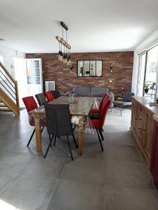 uma sala de estar com uma mesa de madeira e cadeiras vermelhas em Le Repos du Randonneur em Audinghen