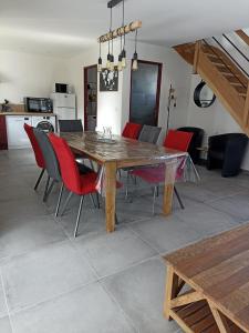 歐丹岡的住宿－Le Repos du Randonneur，一间带木桌和红色椅子的用餐室