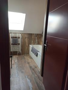 ein Bad mit einer Badewanne und einem Fenster in der Unterkunft Le Repos du Randonneur in Audinghen