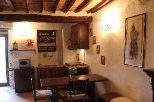 a kitchen with a wooden table and a kitchen with a table and chairs at Petite Maison in Cetona