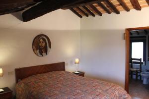 a bedroom with a bed and a mirror on the wall at Petite Maison in Cetona