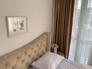 uma cama num quarto com uma grande janela em Magheru cozy new apartament 2 rooms em Bucareste