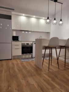 a kitchen with white cabinets and a table and chairs at somtresapartament in Platja d'Aro