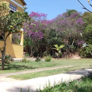 a house with a yard with purple flowers at Hospedaria Estrada Real in Tiradentes