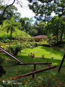 a garden with a slide in the grass at Sitio Recanto da Paz Chalés - casa e chalé para temporada in São Pedro da Serra