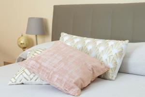 uma cama com uma almofada cor-de-rosa e almofadas em Interno Estense 753 em Ferrara