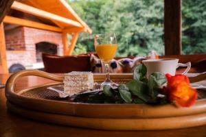 una mesa con un plato de comida y un vaso de zumo de naranja en Eden Visoko, en Visoko
