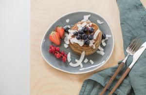 a plate with a waffle with fruit and whipped cream at Salty Woods Lodge, Chambre d'hôtes in Vieux-Boucau-les-Bains