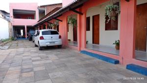 a white car parked next to a building at Pousada Meu Paraíso in Lagoinha