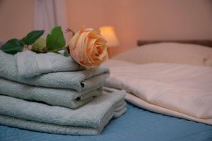 una pila de toallas y una rosa en una cama en Eden Visoko, en Visoko