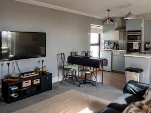 a living room with a flat screen tv and a piano at Penarth Town (Cardiff) - Private Sun Terrace! Ideal For Families & Couples! in Cardiff