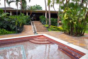 a swimming pool in front of a house with palm trees at Luxva Hotel Boutique in Guayaquil