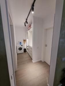 a room with a hallway with a washing machine and a microwave at Apartament SUPERB in regim Hotelier- Arad Plaza in Arad